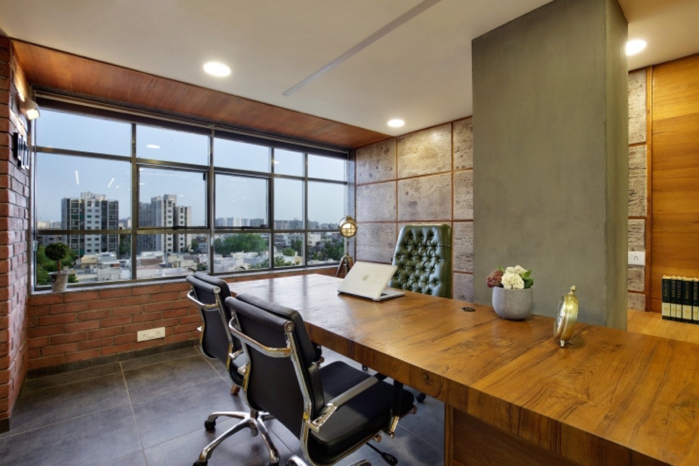 A director's cabin with a long timber desk, leather chairs and a wide window over the city