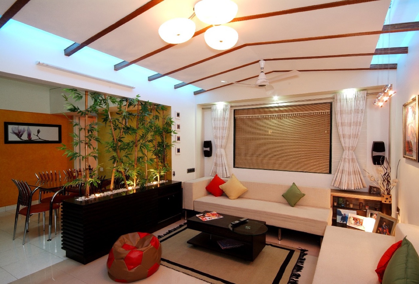 A living room with an indoor bamboo planter, low sofa and timber ceiling battens