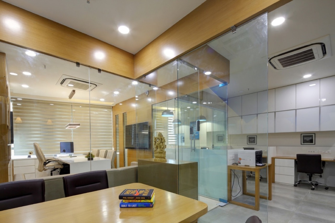 An open office seen through glass partitions, with a meeting table in front
